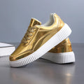 Gold sequinned platform sneakers with round toe and thick MD sole on white background.