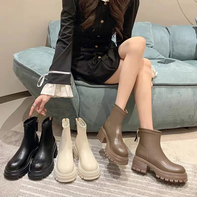 White platform ankle boots for women with thick foam rubber sole, mid-calf shaft, square heel, round toe, and back zipper.