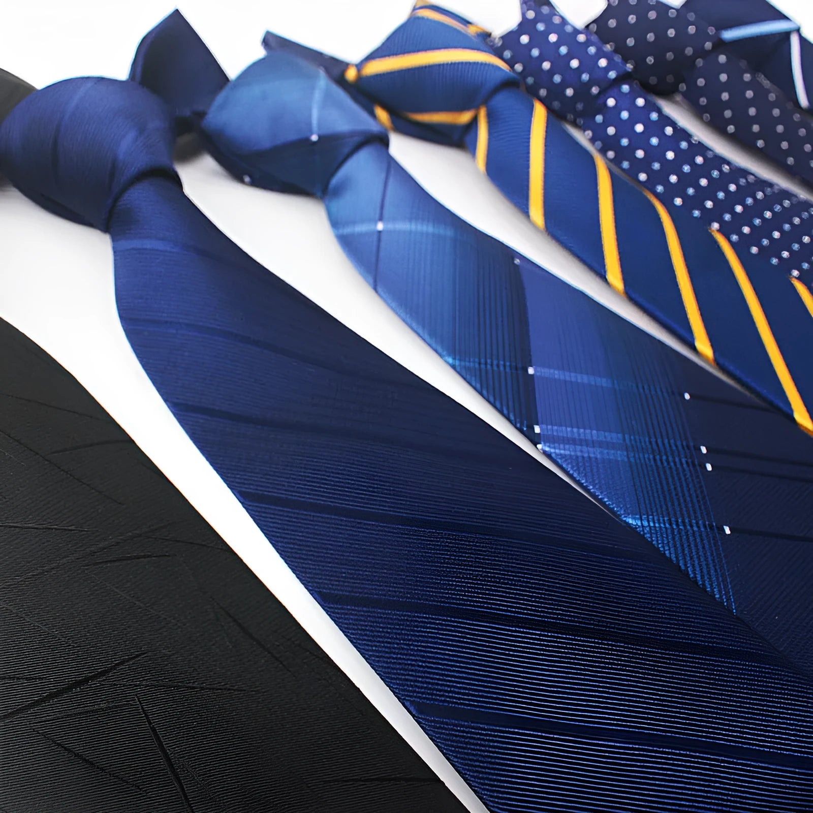 Close-up of a red, black, and blue striped jacquard polyester business tie with an arrow style shape.