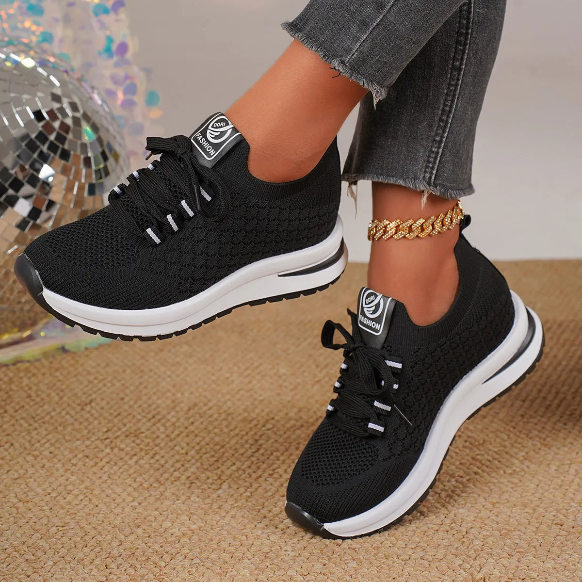 Women's black lace-up mesh sneakers with a flat rubber sole and round toe on a white background.