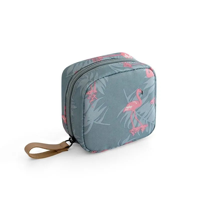 Blue cloth cube-shaped makeup bag with a zipper closure, resting on a surface.