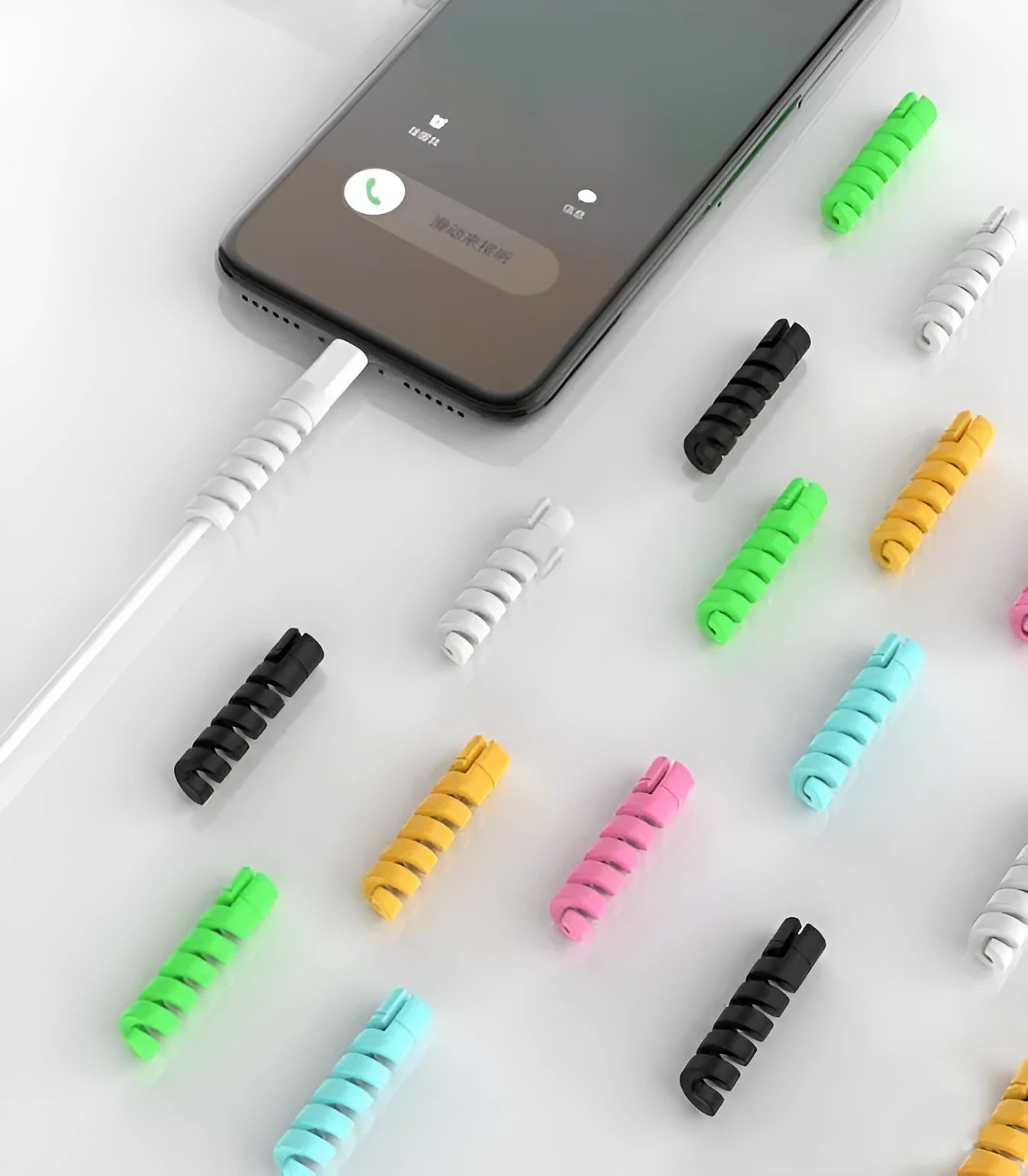 Two plastic cable protectors, 3.5cm long, in assorted colours next to a charging cable.