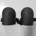 A pair of thick EVA foam knee pads in army green colour, shown on a wooden surface.