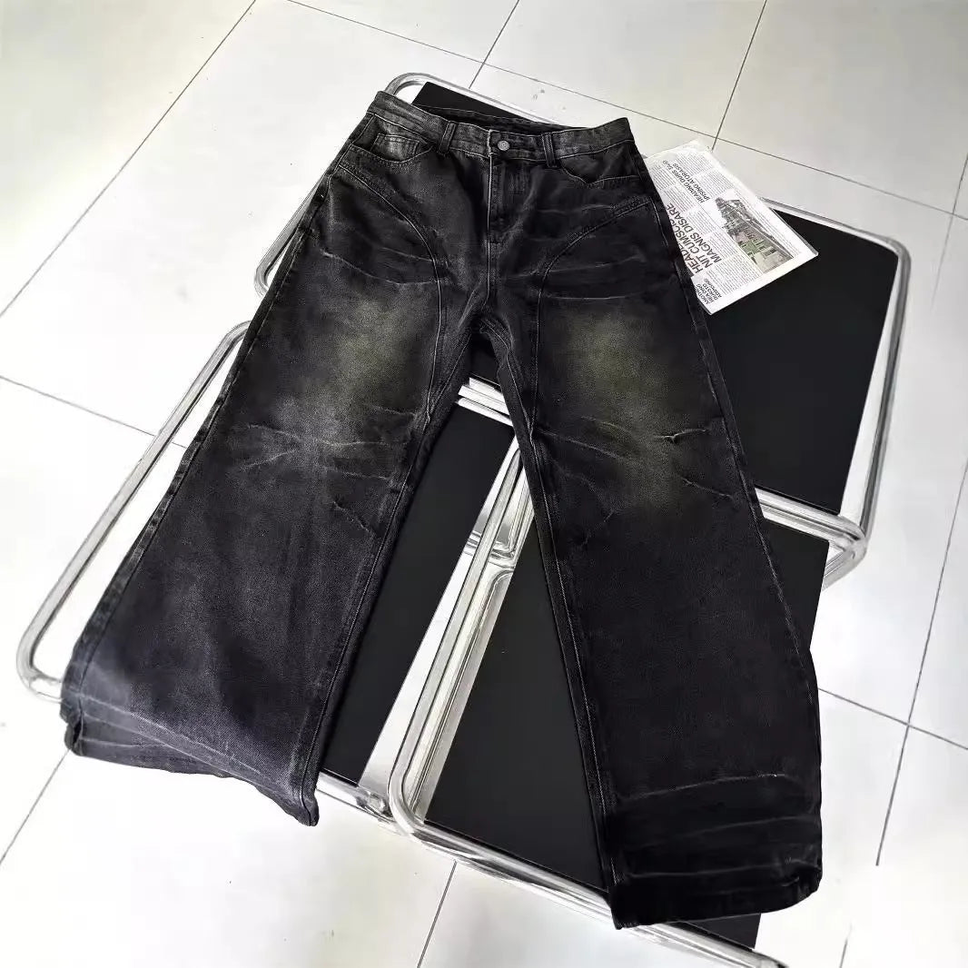 Washed black straight denim trousers with deconstructed dirty mud texture and zipper fly