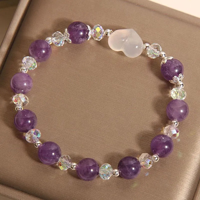 Natural amethyst bracelet with white agate love heart charm on a light background