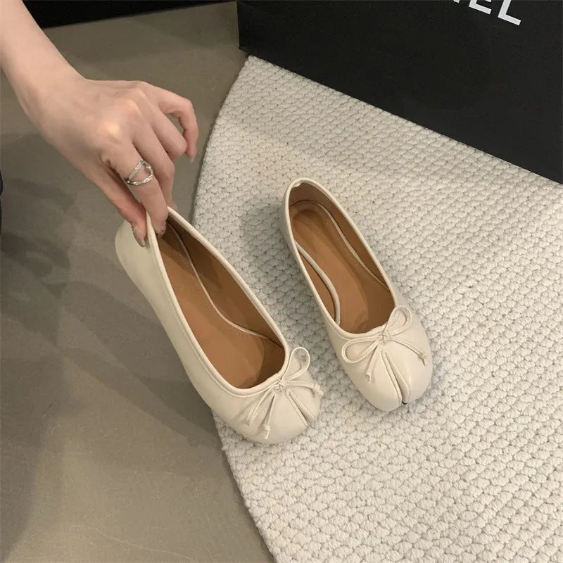 Women's black split-toe flat pumps with a round toe and slip-on oversleeve design.