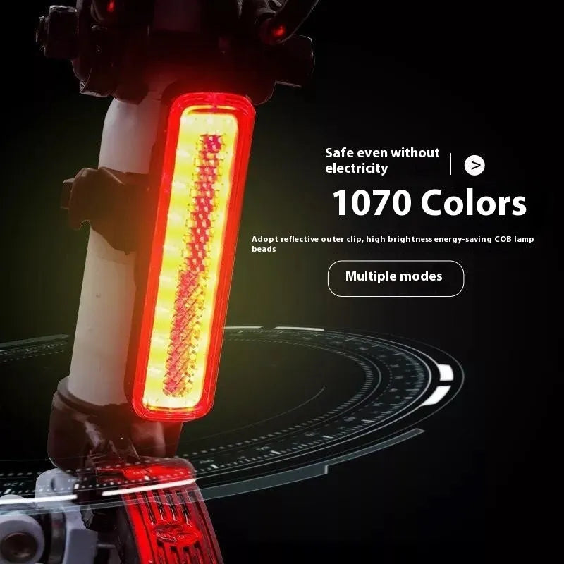 USB rechargeable bicycle light with colourful LED on a bicycle handlebar at night