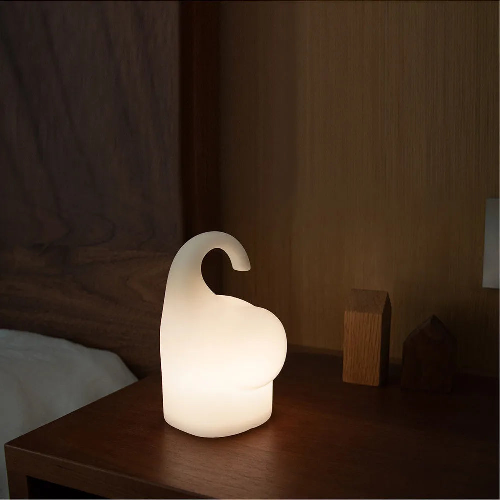 DOMI Elephant-shaped silicone USB night light with warm white glow on a bedside table.