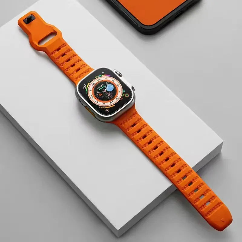 Fluoro rubber Apple Watch replacement strap with T buckle in one of six colours on a wrist.