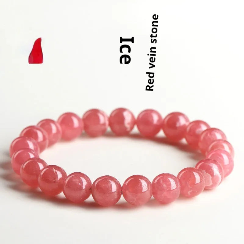 Women's geometric Rhodochrosite crystal bracelet with Longevity Lock feature on a wrist, showing red patterned stone beads.
