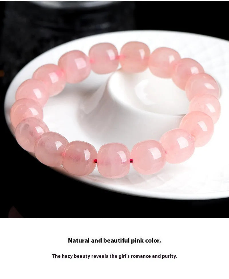 Pink crystal barrel-shaped bead bracelet on a wrist, showing geometric beads and polished finish.