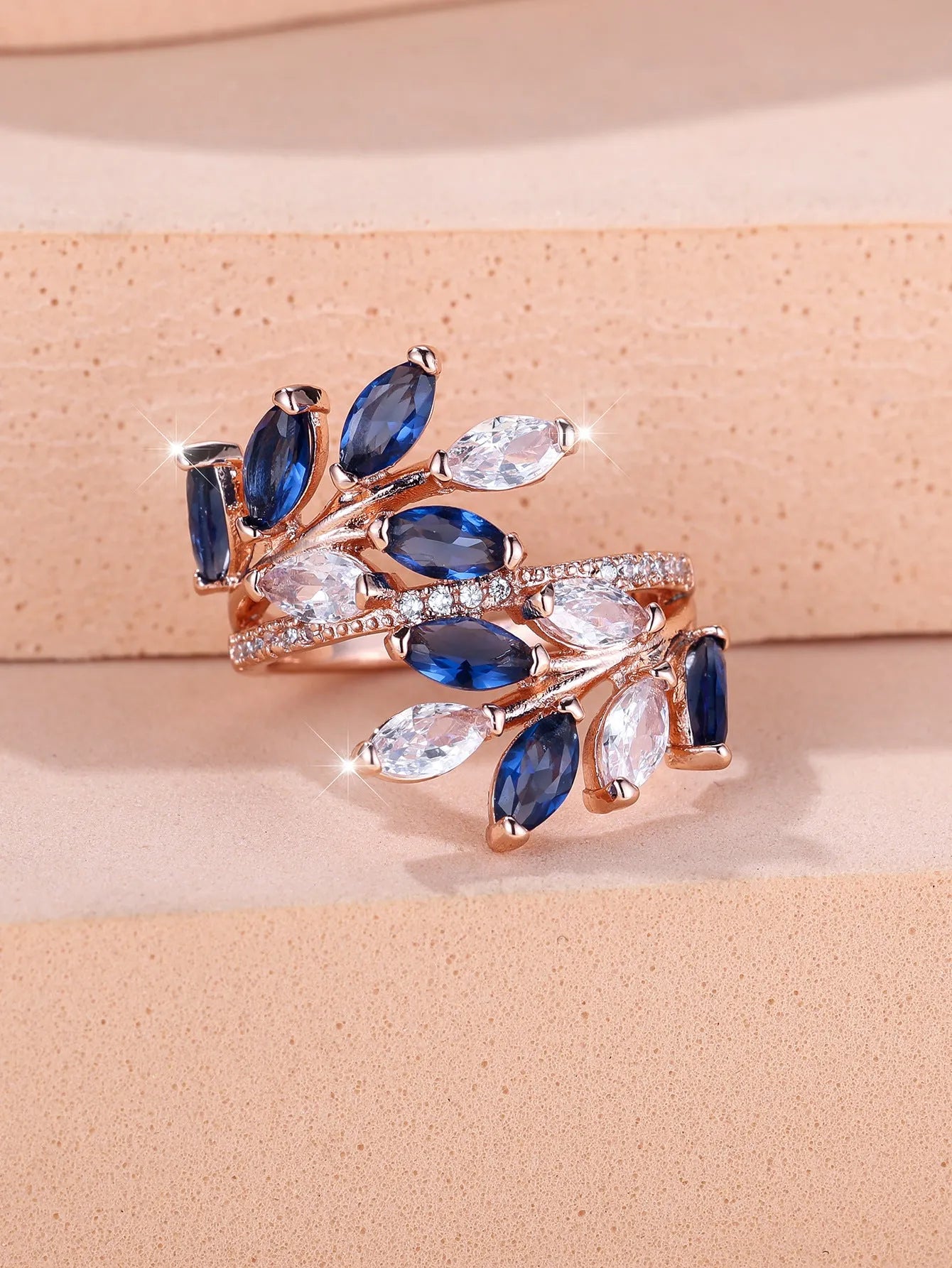 Adjustable leaf ring with horse eye zircon stone in rose gold finish on wooden background