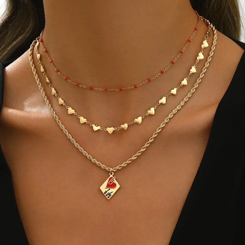 Gold tone three-layer love necklace with geometric pendant on a model.