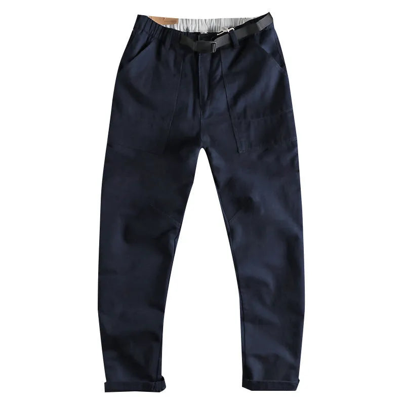Men's khaki cotton work trousers with a buckle belt and three-dimensional cut on a hanger.