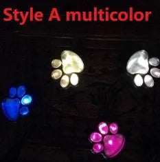 Black solar powered bear paw print garden lights with four paw design on grass