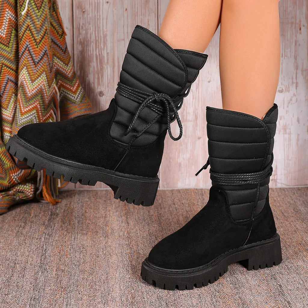 Women's black chunky heel snow boots with lace-up front and fleece lining.