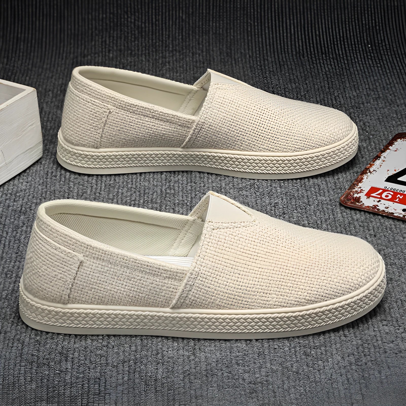 Men's beige canvas slip-on shoes with round toe and PVC sole on a plain background