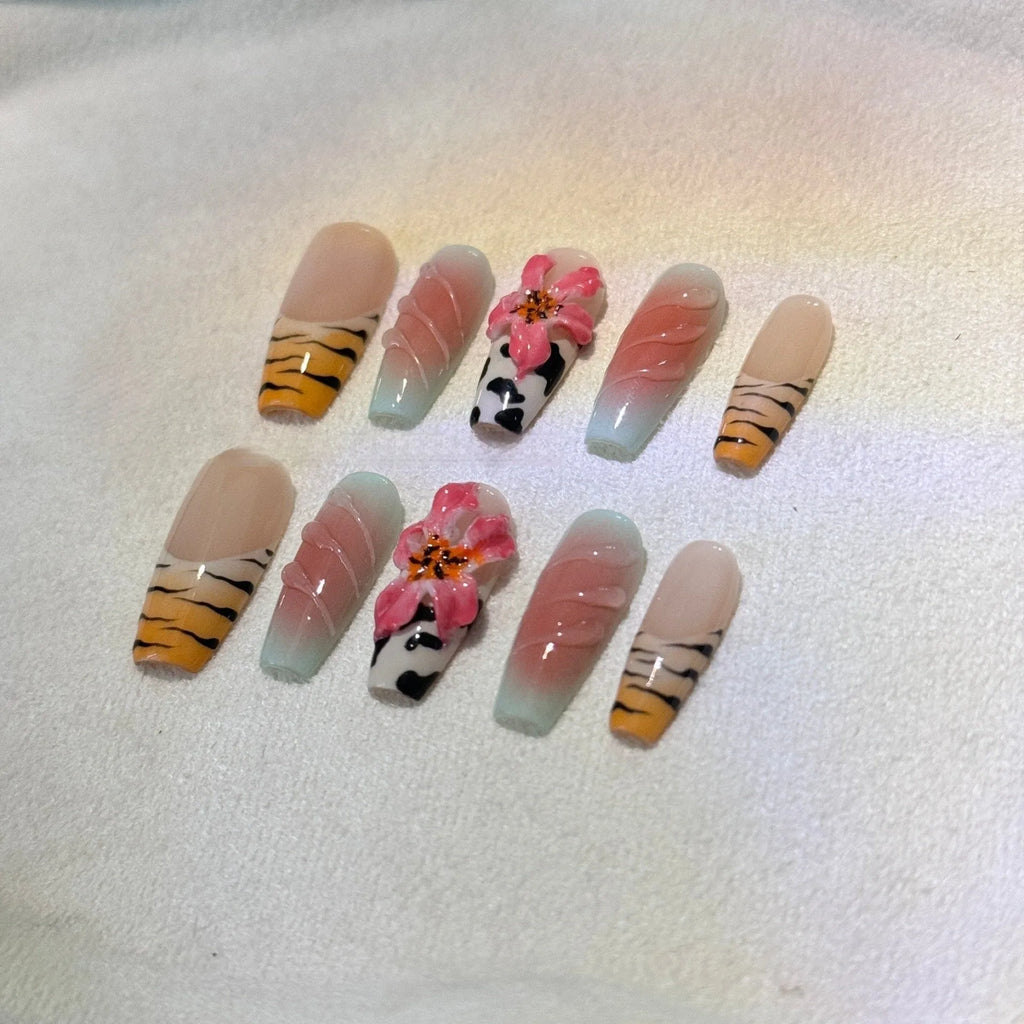 Hand-carved artificial nails with raised zebra pattern and floral designs, shown in long style.