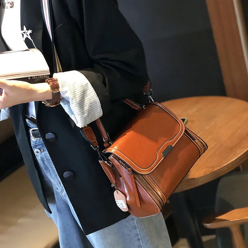 Women's brown genuine leather retro messenger bag with double strap and external pockets.