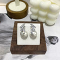 Curved zircon pearl earrings in gold tone and silver tone with cat eye stone or white pearl detail