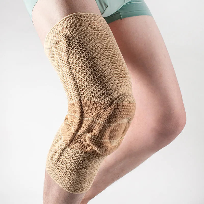Adult black and blue sports knee pad made of nylon and spandex, shown on a knee.