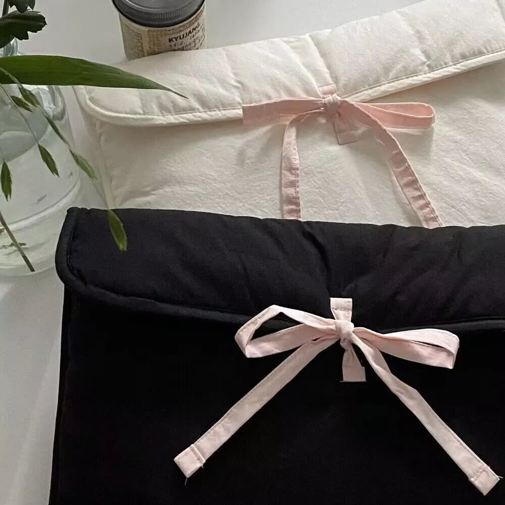 Black and white quilted women's laptop bag with striped pattern and a ballet-style bow.