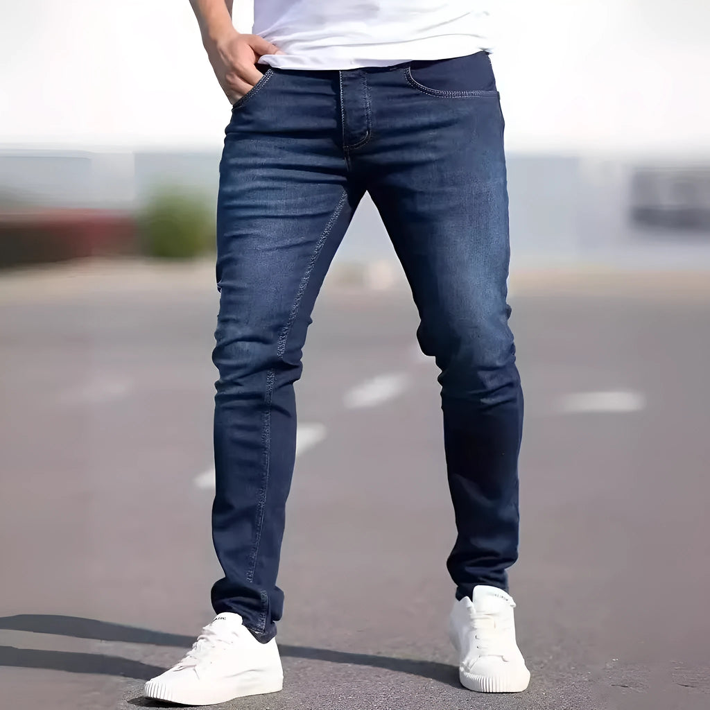 Men's dark blue slim fit cotton jeans showing skinny leg silhouette and street fashion style