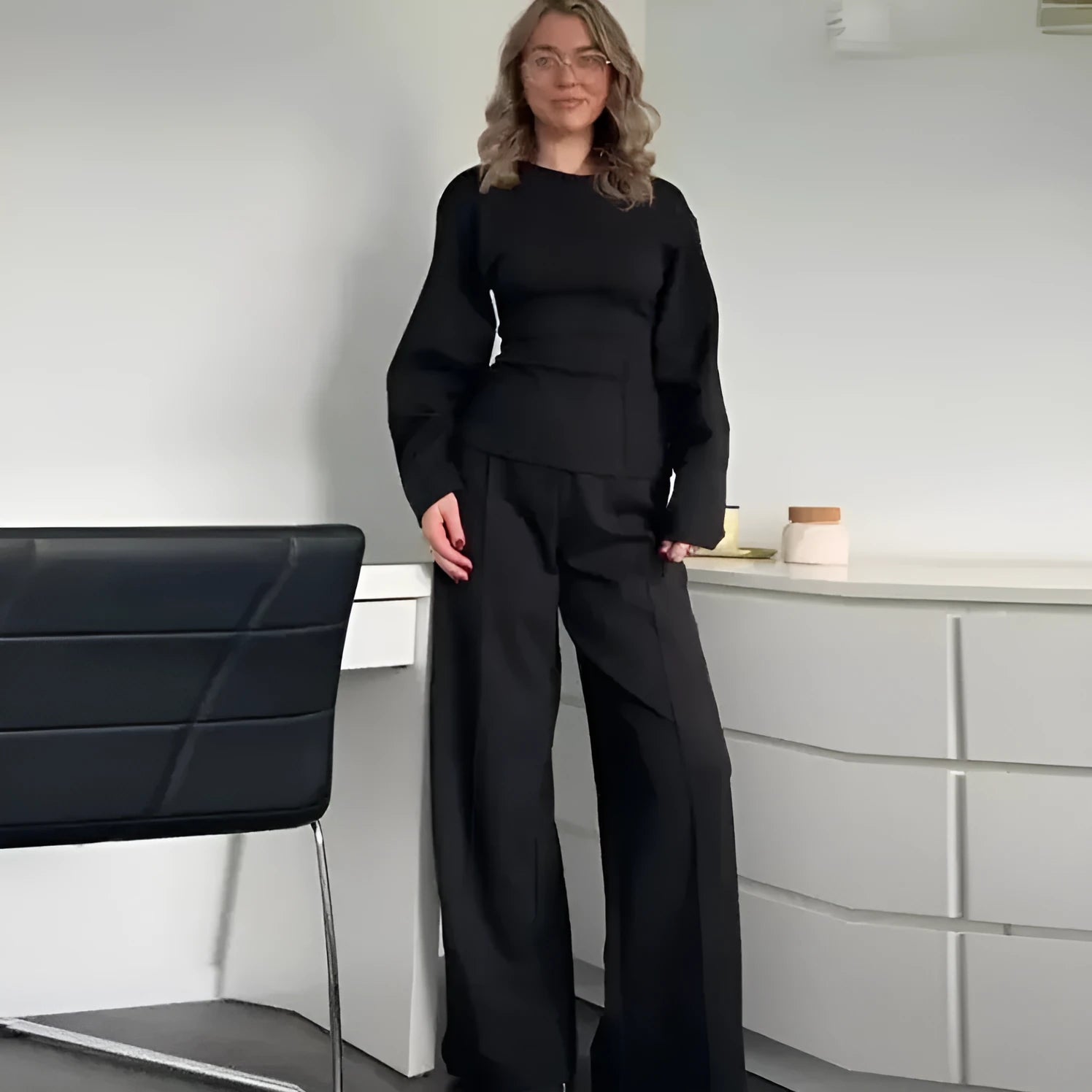 Women's black polar fleece suit with O-neck long sleeve top and wide-leg trousers on a hanger