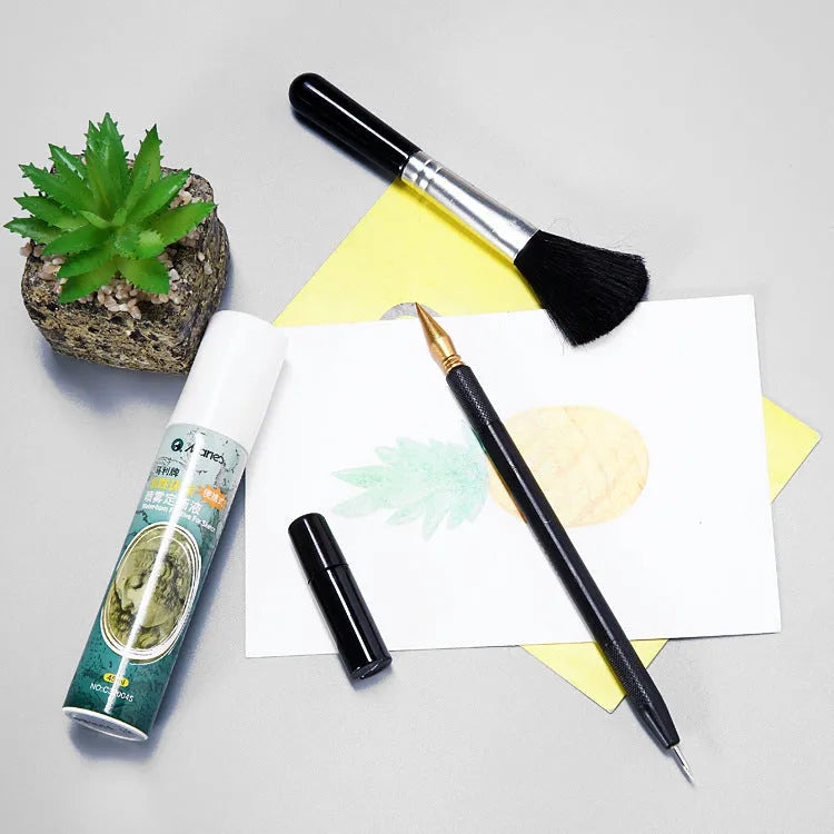 Scratch painting tools set with white card, 14.5cm long tool, brushes, and photo frames on a table.