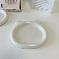 White round porcelain plant plate with a bear doodle design, shown under a small succulent pot.