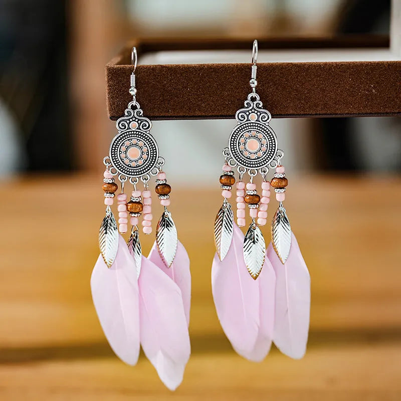 Bohemian style feather drop earrings with round oil craft design in alloy material showing leaf pattern detail