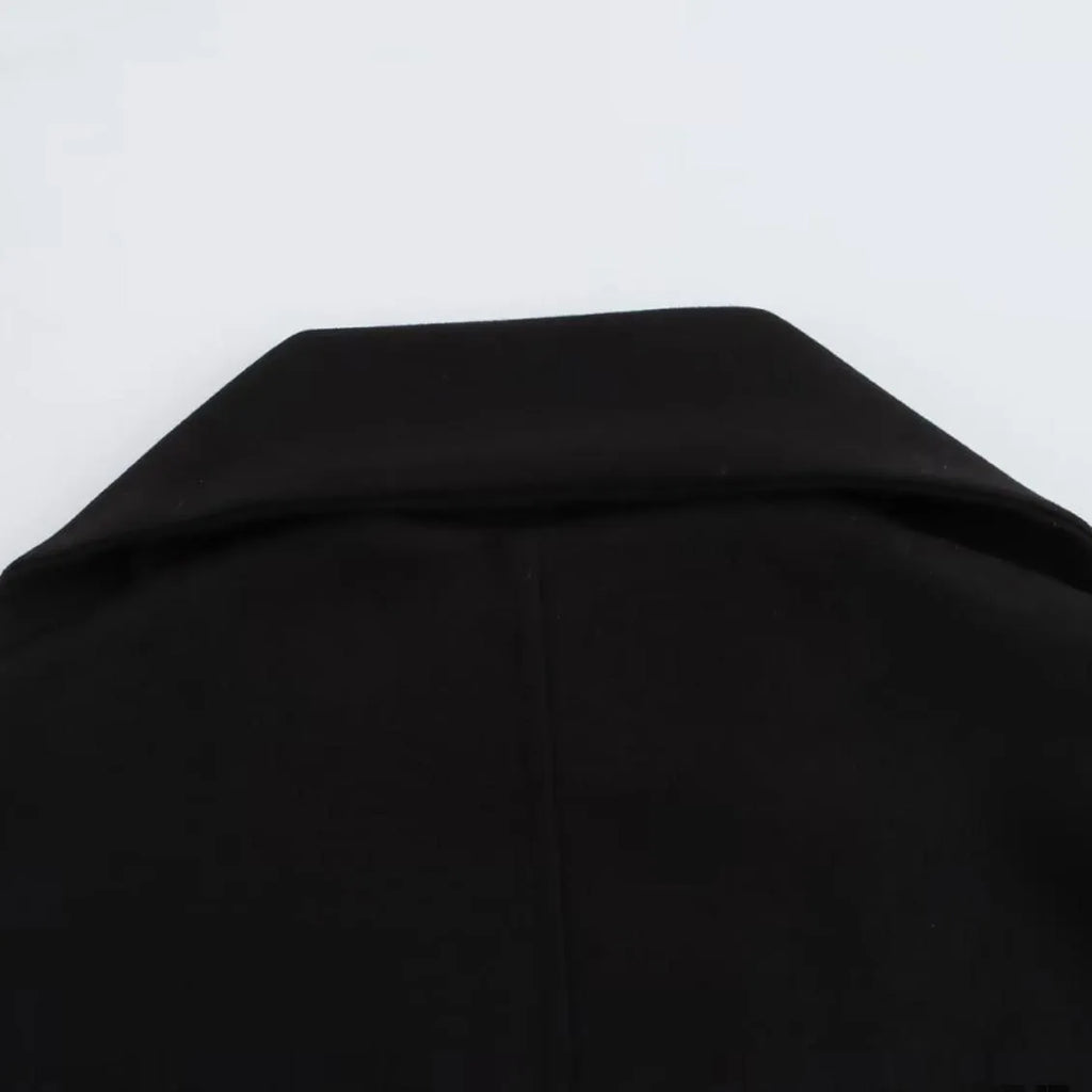 Women's long black overcoat with artificial fur collar, showing extended length and street fashion style.