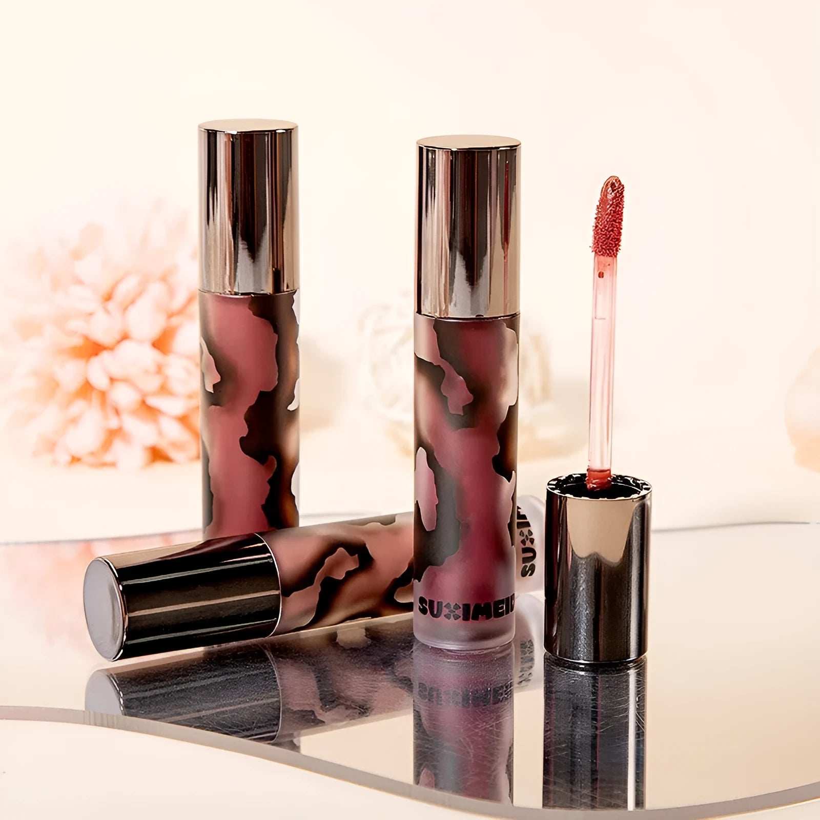 Matte lip mud lipstick in tube showing five colour shades: orange brown coffee, cool grey, cinnamon coffee, jujube red, smoked purple.