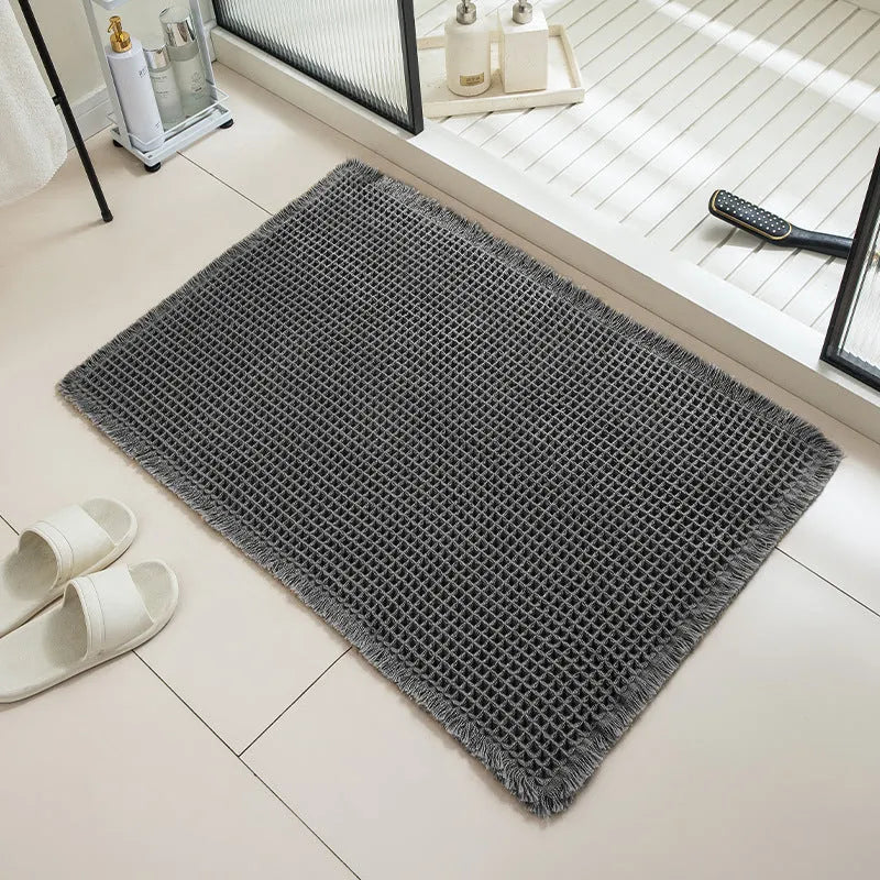 A square, checkered-pattern bathroom carpet in a choice of colours on a tiled floor.