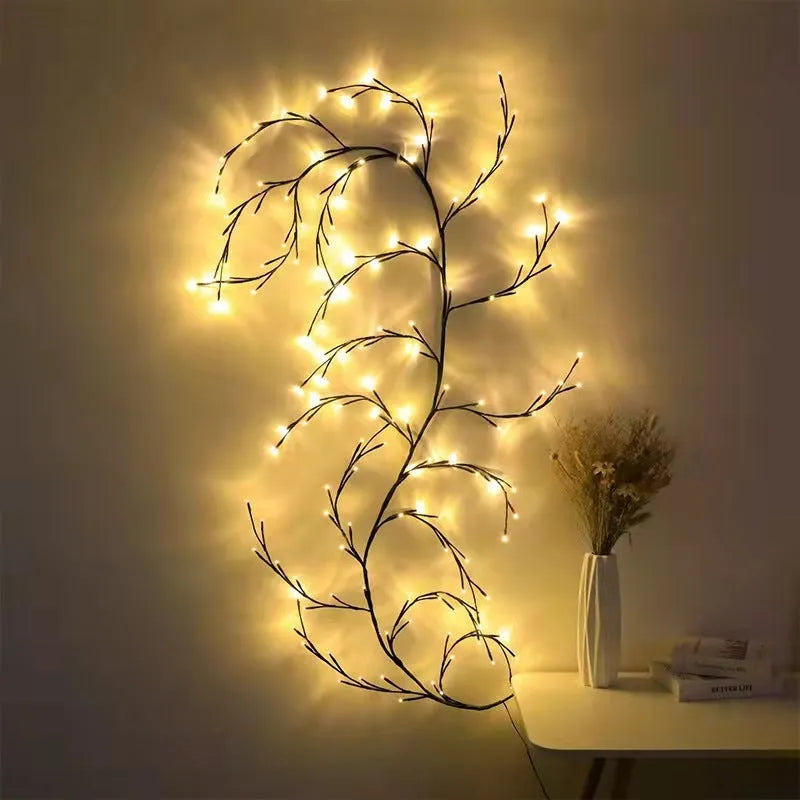 Flexible willow vine Christmas garland with warm white LED lights bent into a decorative shape on a wall.