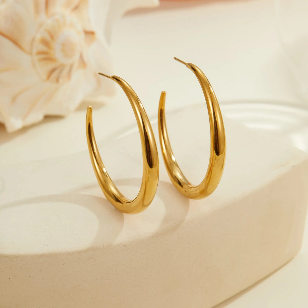Simple round titanium steel hoop earrings for women in gold and steel finishes, shown in small and large sizes.
