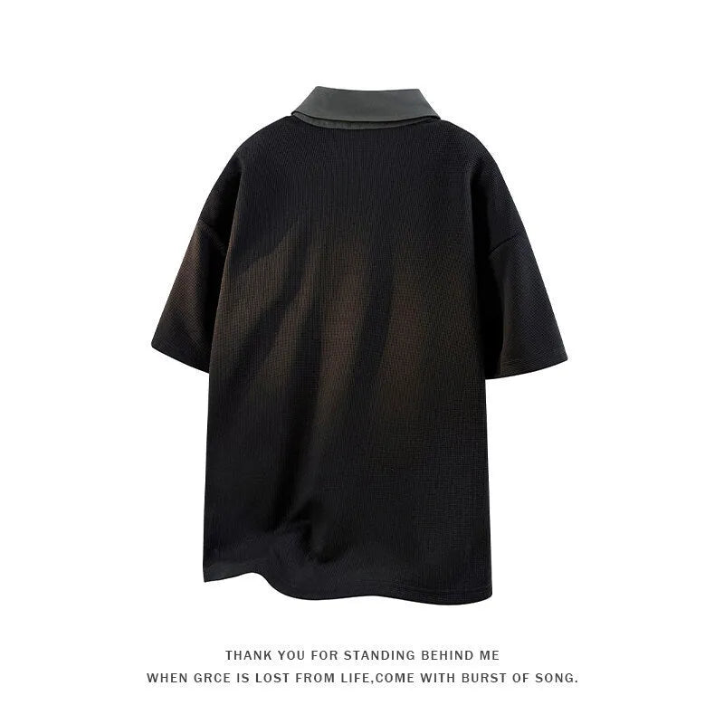 Man wearing a black padded Henry collar polo shirt sweater with short sleeves.