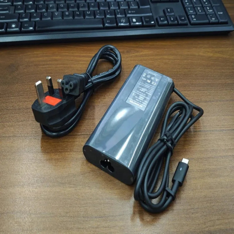 Black 65W USB-C laptop power adapter with multiple international plug attachments
