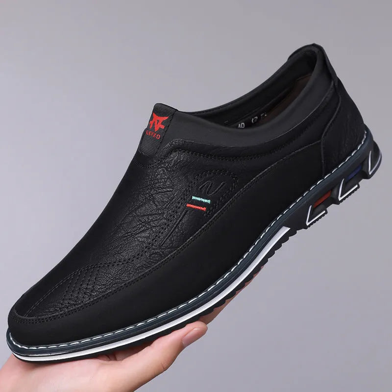 Men's black leather toe cap casual slip-on shoes with a rubber sole on a white background.