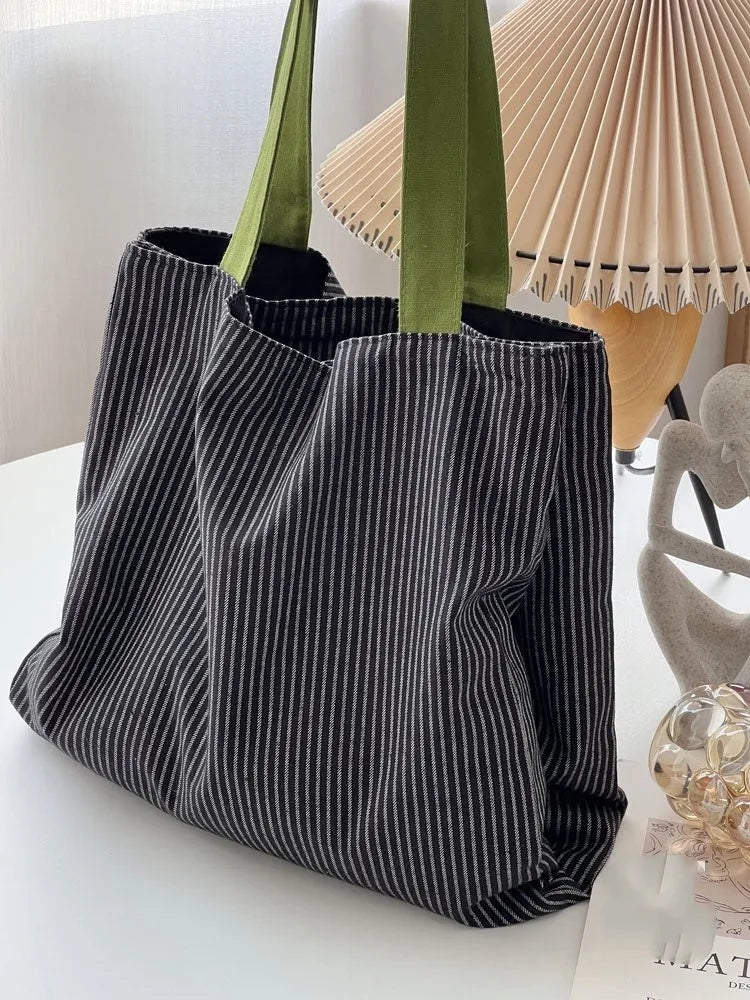 Casual multi-layer canvas tote shoulder bag in a plaid pattern with a wide strap.