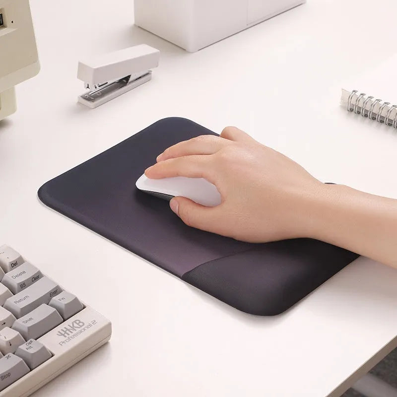 Square black silica gel wrist rest mouse pad with cloth surface on a desk.