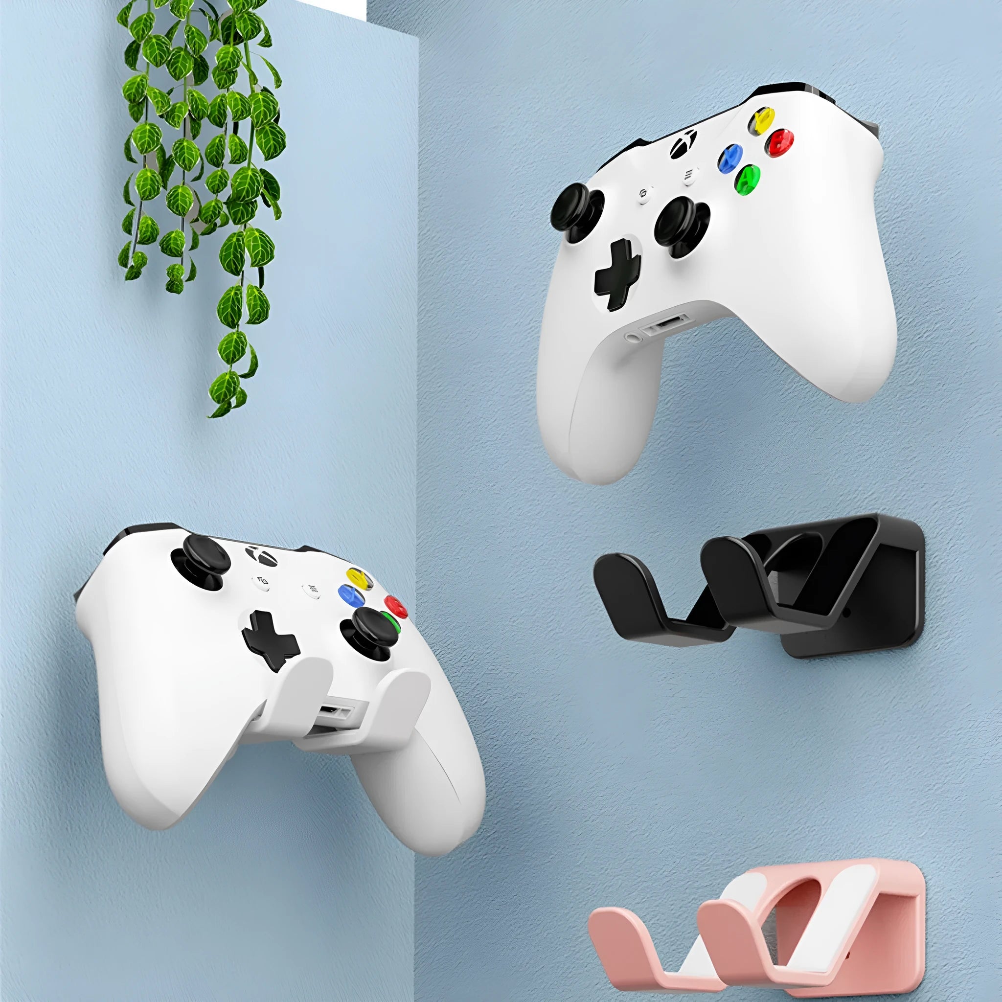 Black ABS plastic X-shaped handle wall hanging rack mounted on a white wall with adhesive glue.