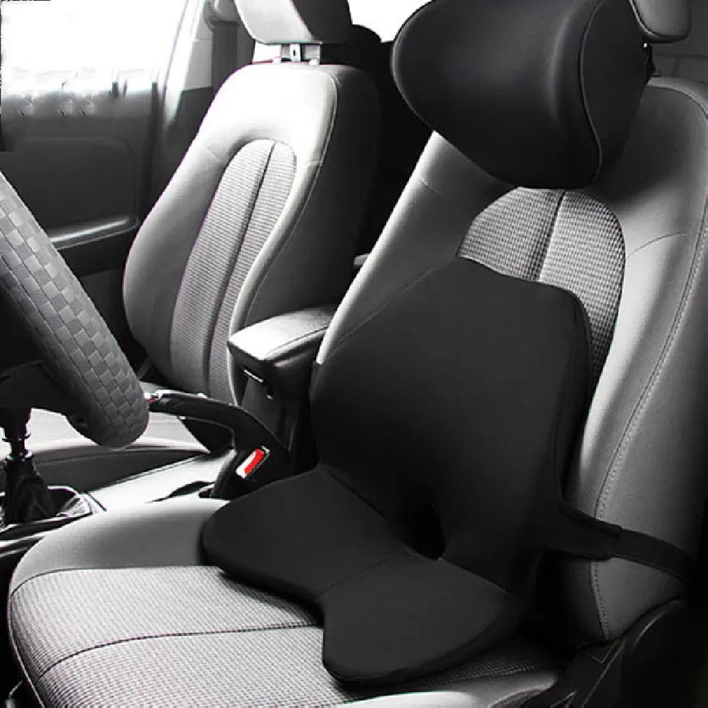 Black memory foam car lumbar support cushion with elastic straps, shown on a grey car seat.