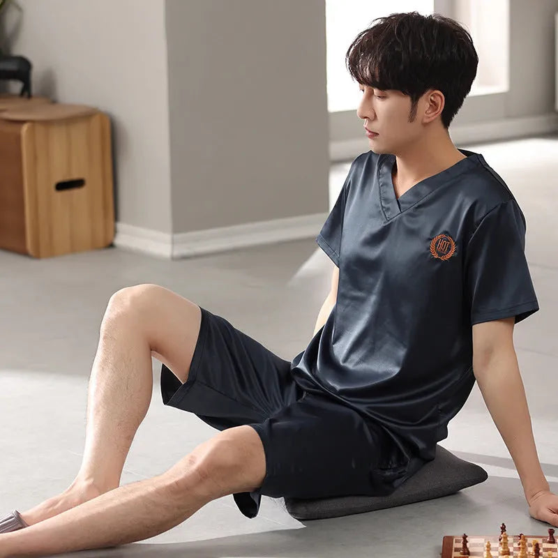 Man wearing a light blue ice silk short-sleeve pajama shirt and matching loose shorts.