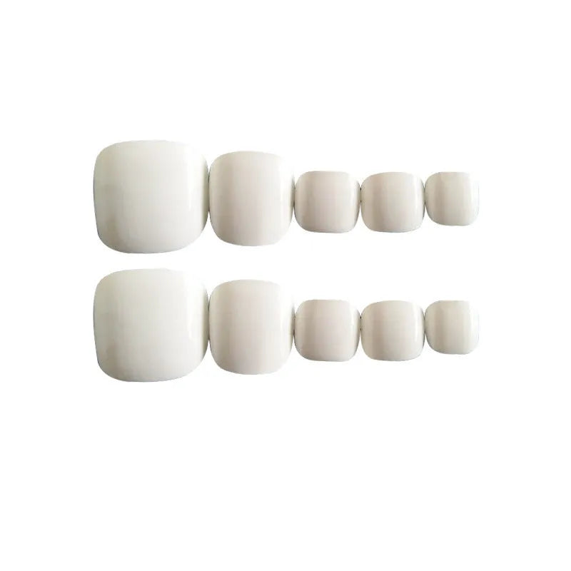 Set of white press-on false nails with a starry sky pattern, laid out for a manicure.