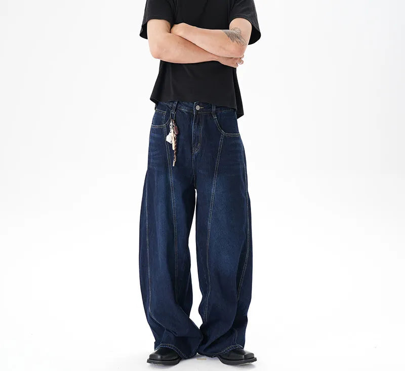 Dark blue distressed wide leg jeans with a machete cut design on a denim fabric.