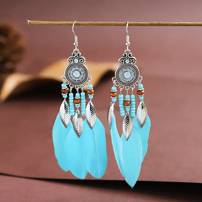 Bohemian style feather drop earrings with round oil craft design in alloy material showing leaf pattern detail