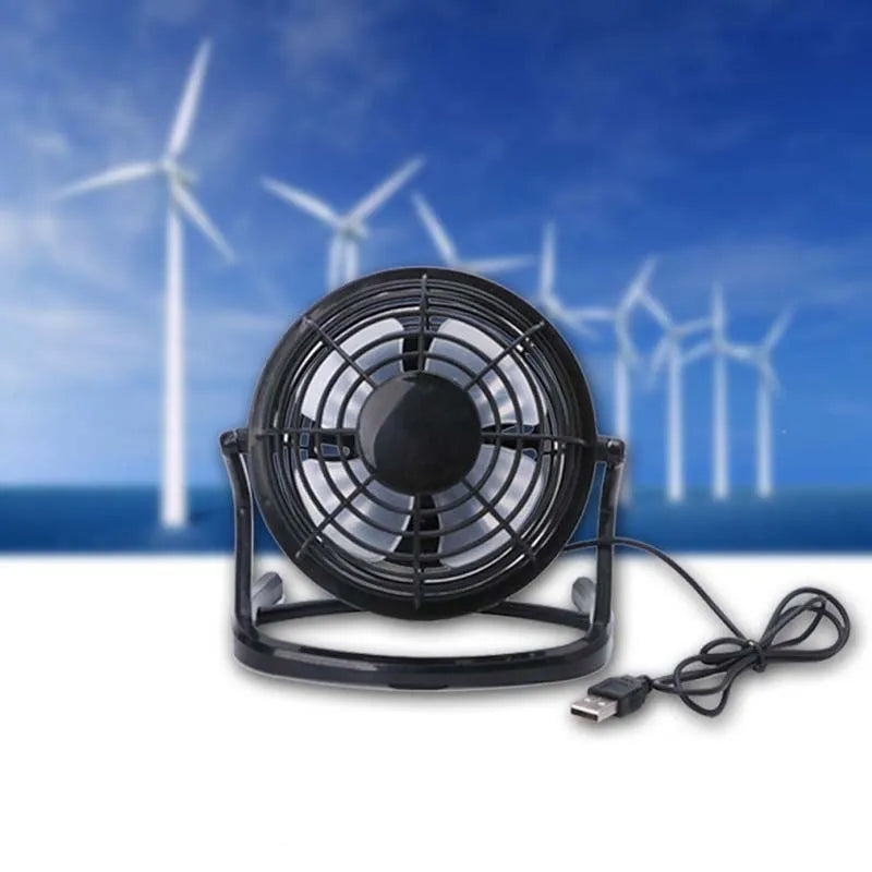 Small black USB desk fan with adjustable head and key switch on a wooden desk.