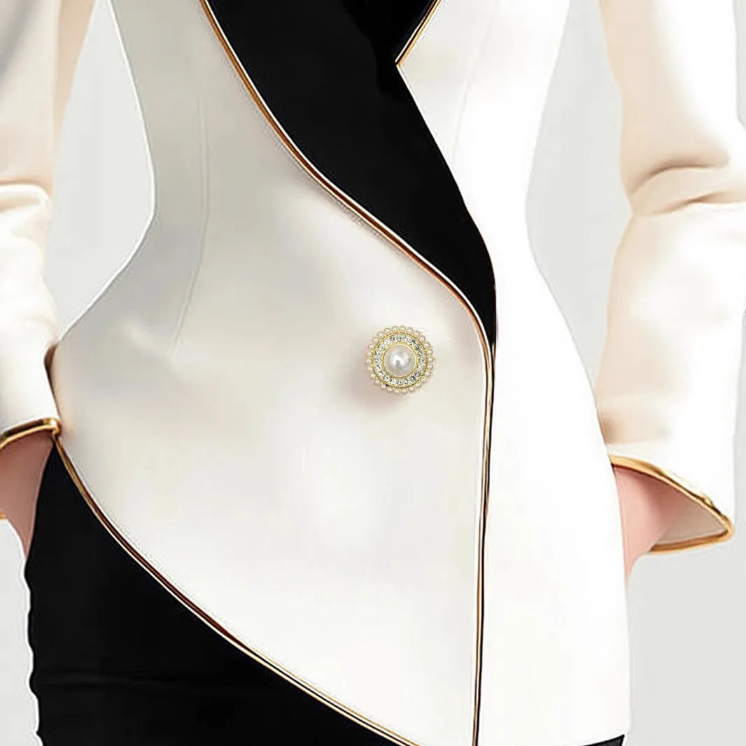 Women's milky white irregular cut long sleeve coat with golden pearl buttons on a hanger.