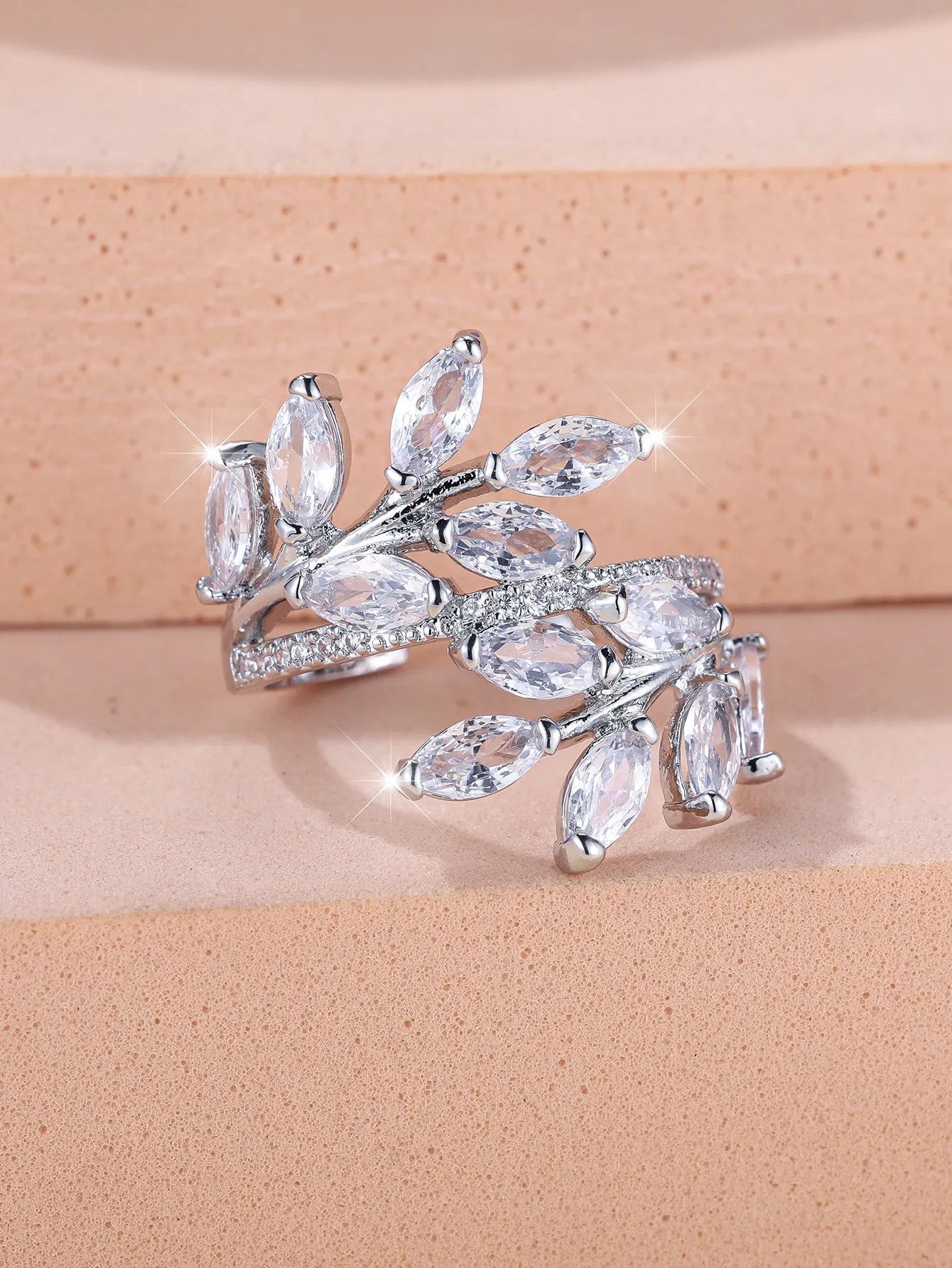 Adjustable leaf ring with horse eye zircon stone in rose gold finish on wooden background